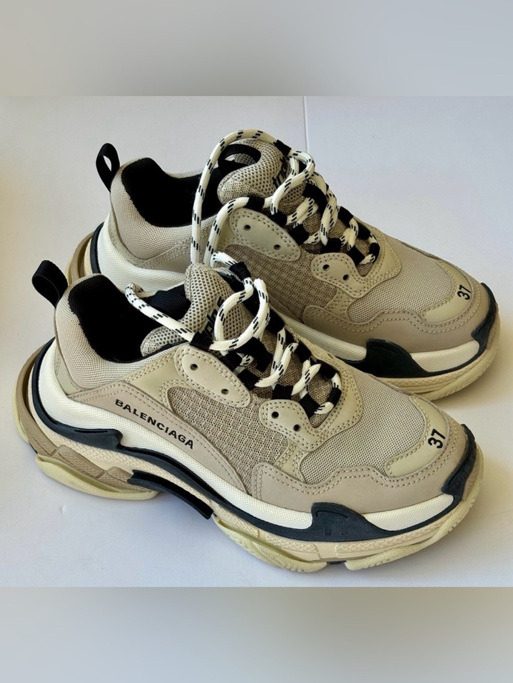 Balenciaga Triple S chunky sneakers in beige/cream with black detailing.